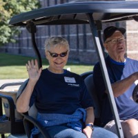 GVSU Alumna waves while she passes by on golf cart